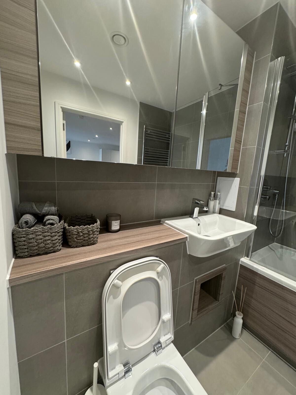 Un baño moderno con inodoro, lavabo y ducha.