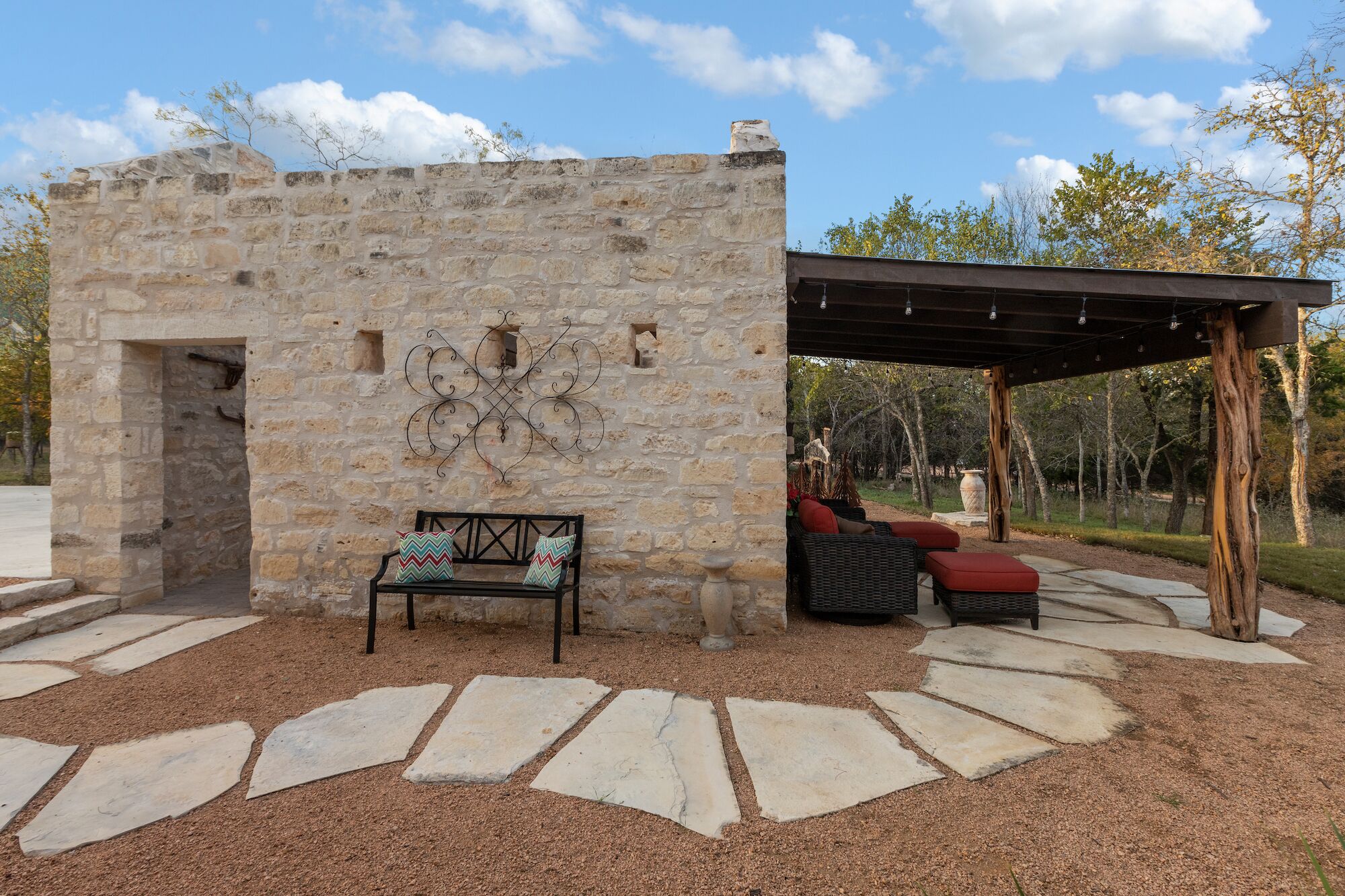 A stone structure with a bench and a covered seating area.