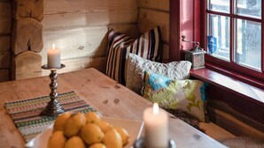 A cozy cabin interior with a wooden table, candles, a bowl of oranges, and a window with a view. - Amazing apartment in Bjorli with WiFi (Bjorli)