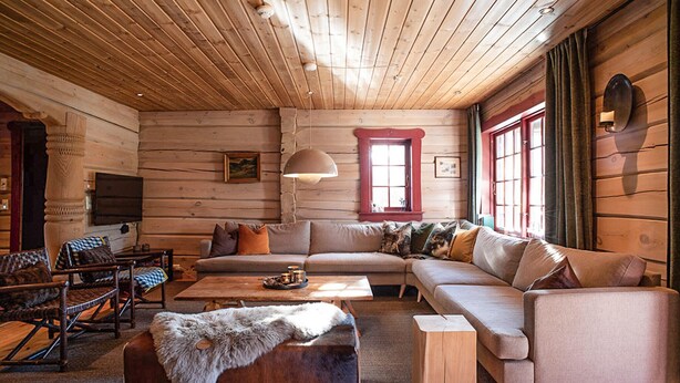 A log cabin interior with a large sofa, a wooden coffee table, a fur throw, and a television. - Amazing apartment in Bjorli with WiFi (Bjorli)