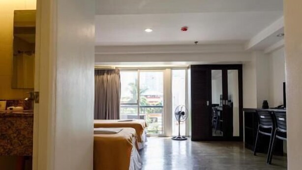 Habitación de hotel con una cama grande, un escritorio y vistas al exterior.