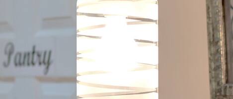 A pendant light with a white shade hanging in a room.