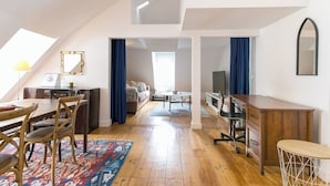 Un loft amplio con comedor, sala de estar y un gran ventanal que proporciona luz natural.