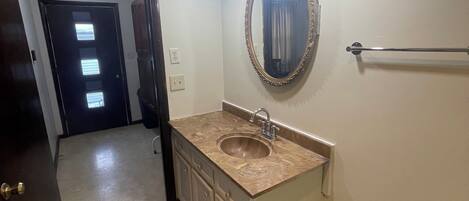 A bathroom with a sink, mirror, and light fixtures.