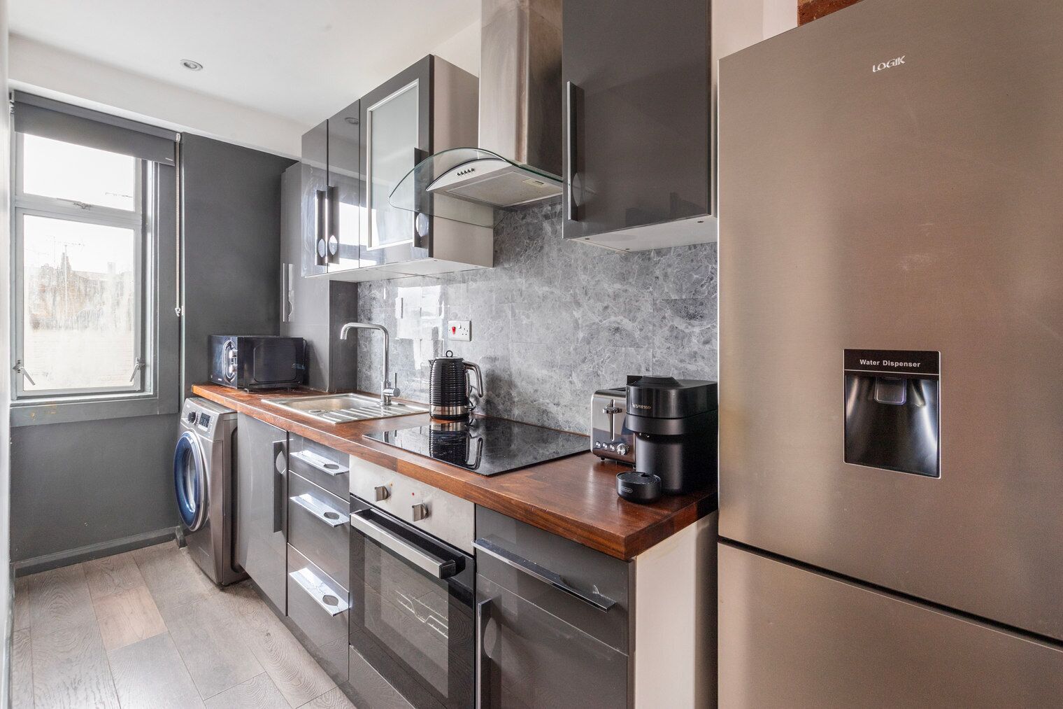 Een koelkast, een magnetron, een oven, kookgerei, borden en bestek