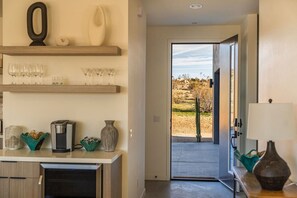 A kitchen with a coffee machine, a toaster, and a vase on the counter. - Inez | Modern Desert Retreat (Yucca Valley)