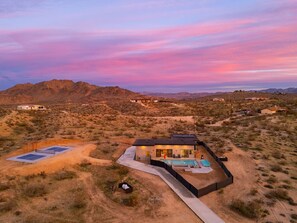 A modern house with a swimming pool, surrounded by a desert landscape. - Inez | Modern Desert Retreat (Yucca Valley)