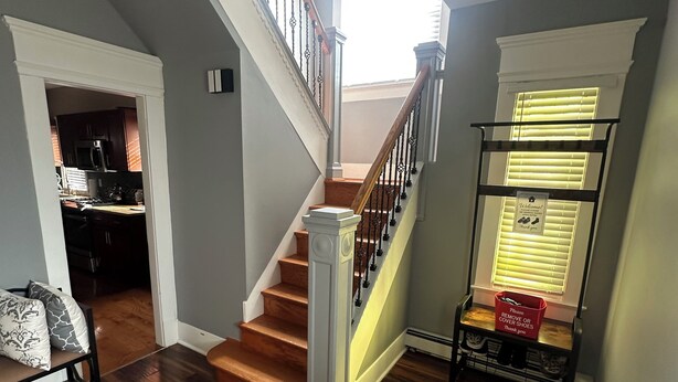 A staircase with a wooden finish and white railings, leading to a second floor. - Charming 4-bedroom house in lovely Scranton perfect for families (Scranton)