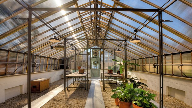 A greenhouse with a metal frame, tables, chairs, and potted plants. - Beautiful Summerville home located 5 minutes from the Augusta National (Augusta)