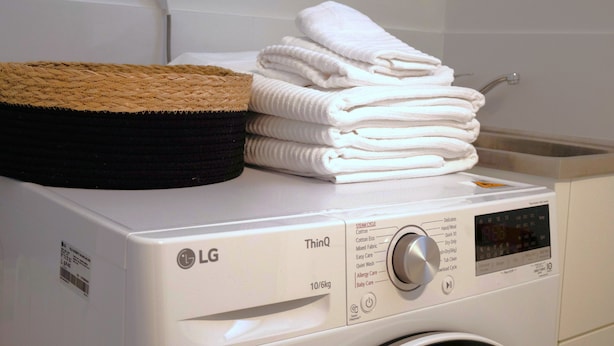 Een witte LG ThinQ wasmachine met een bedieningspaneel waarop verschillende instellingen staan.