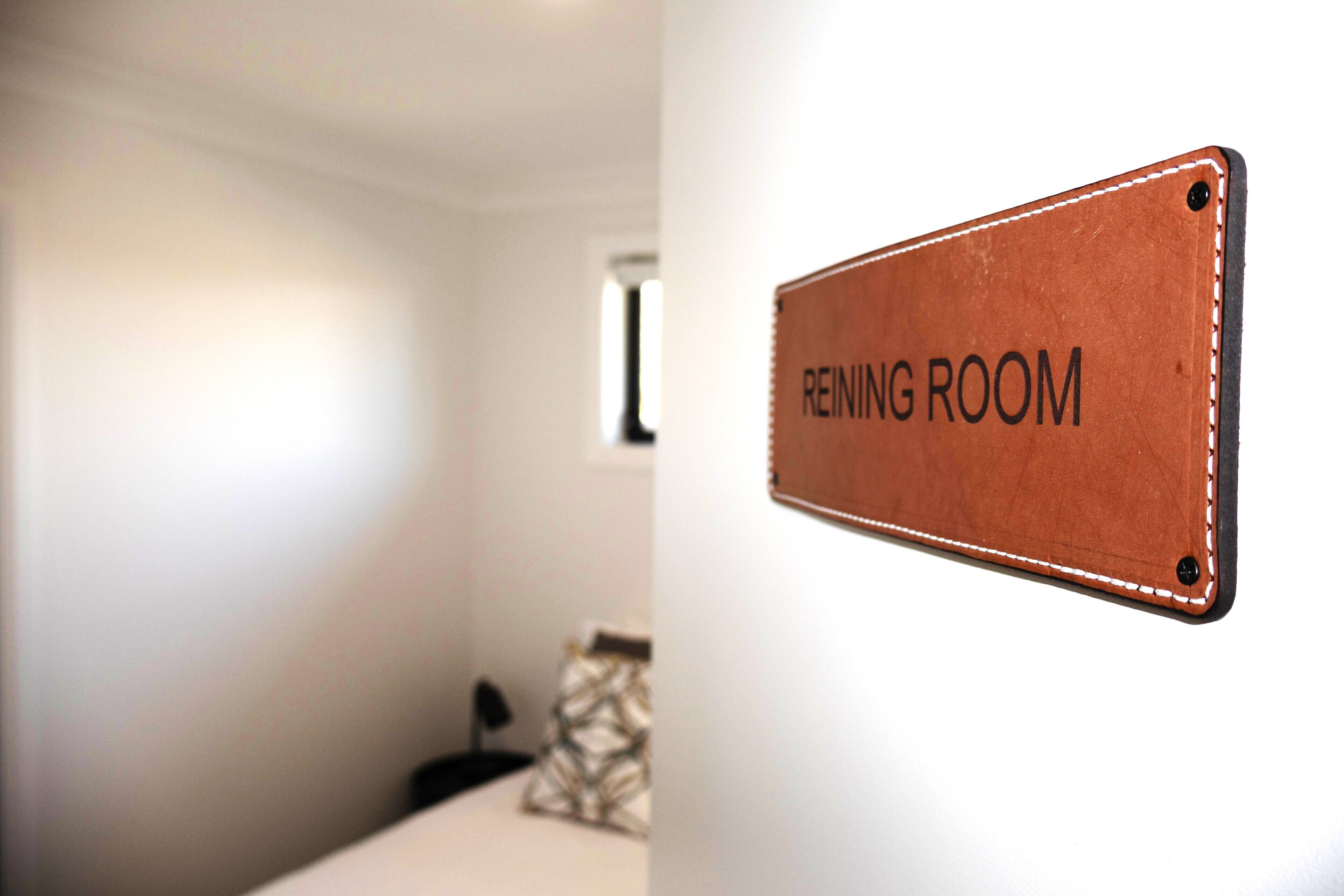 A sign labeled "REINING ROOM" on a wall.