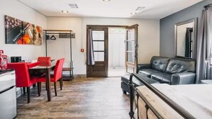 Un espace de vie compact comprenant un coin repas, un canapé et une cuisine.