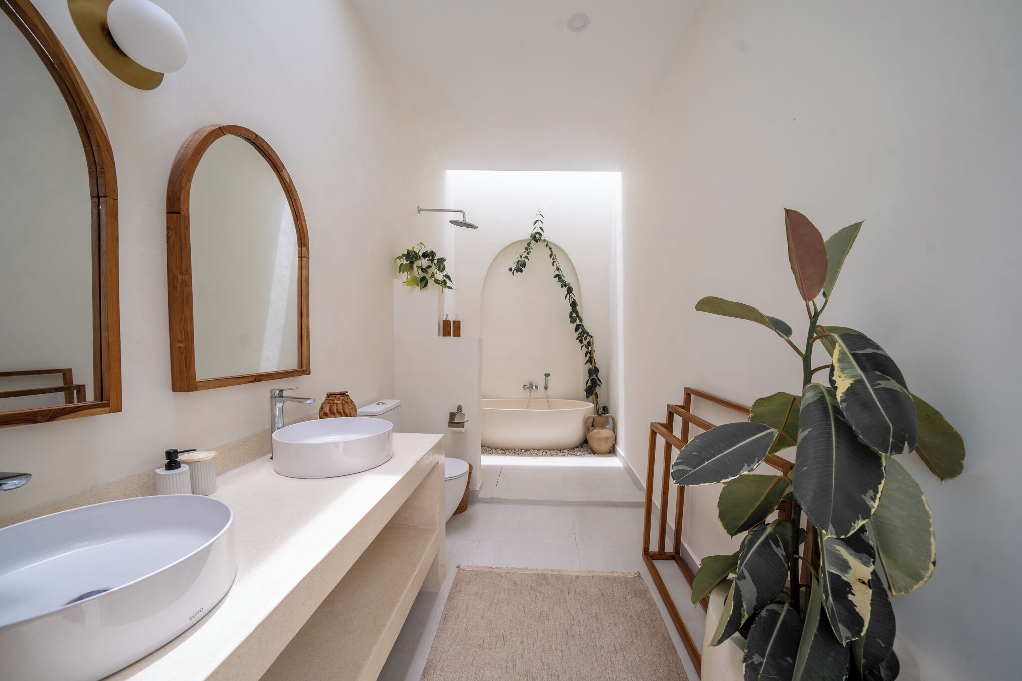 Une salle de bain moderne avec un grand lavabo ovale, une baignoire sur pieds et un miroir encadré en bois.
