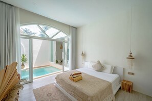 A bedroom with a large bed, a view of a swimming pool, and a sliding glass door leading to an outdoor area. - Villa Marysol Uluwatu (Uluwatu)