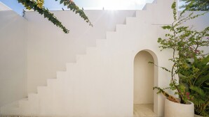 A white staircase leading to an arched entrance, surrounded by white walls and pebbles. - Villa Marysol Uluwatu (Uluwatu)