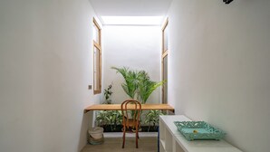 A narrow hallway with a wooden desk, a chair, and a potted plant. - Villa Marysol Uluwatu (Uluwatu)