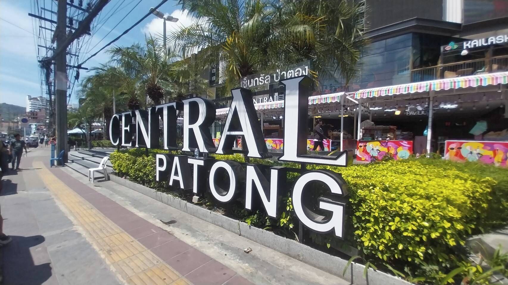 Un gran cartel de Central Patong con un mural colorido de fondo.