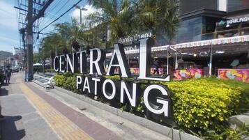 Un gran cartel de Central Patong con un mural colorido de fondo.