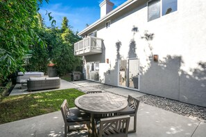 A modern house with a patio, outdoor furniture, and a barbecue area. - Encinitas Getaway | 3-Bedroom Luxury Home | Hot Tub, BBQ | HMS-606 by KBM (Encinitas)