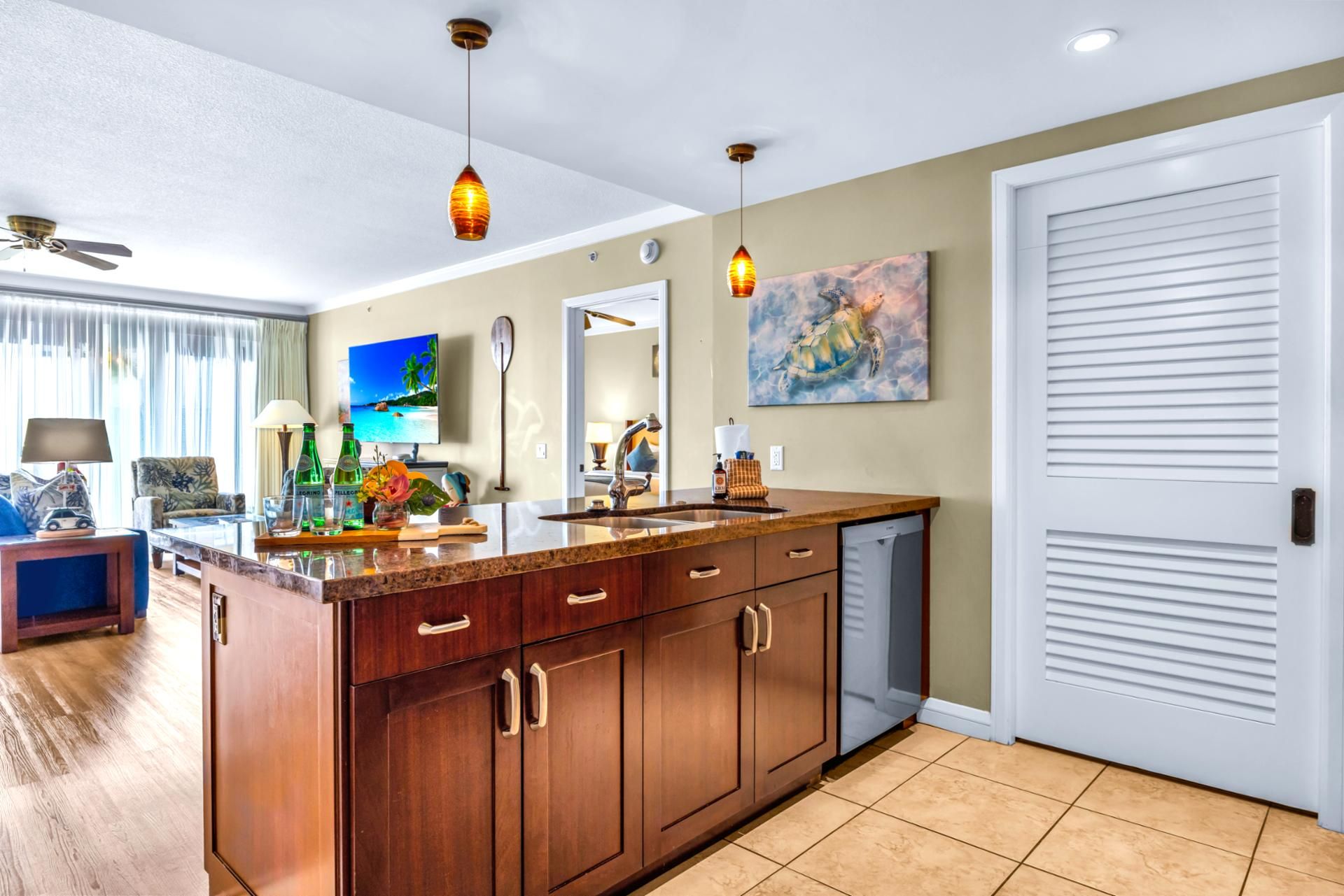 A kitchen with a wooden island, a sink, and a large window.