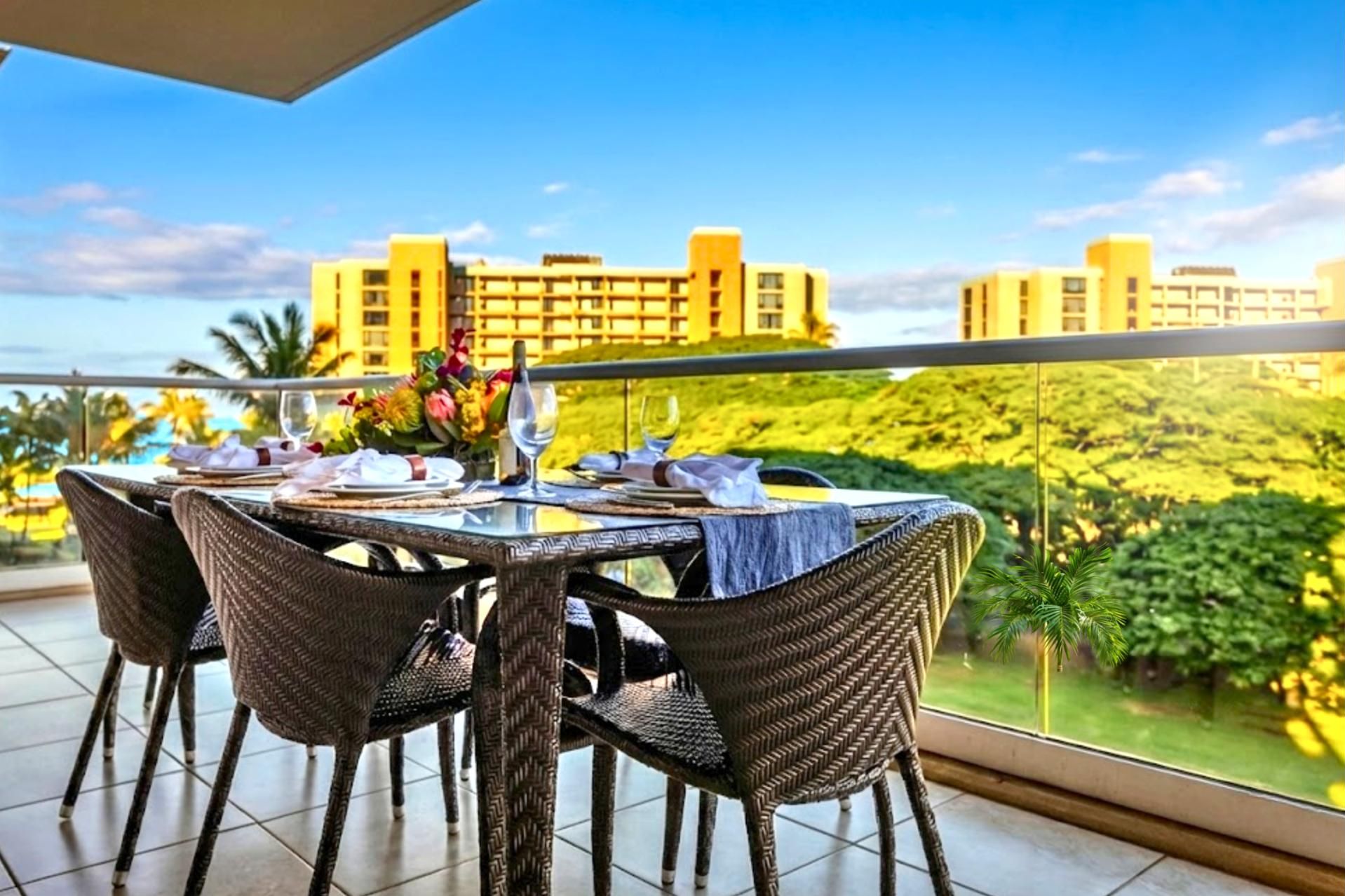 Une table à manger avec des chaises et une balustrade en verre donnant sur un paysage verdoyant et luxuriant, avec des bâtiments aux façades jaunes.