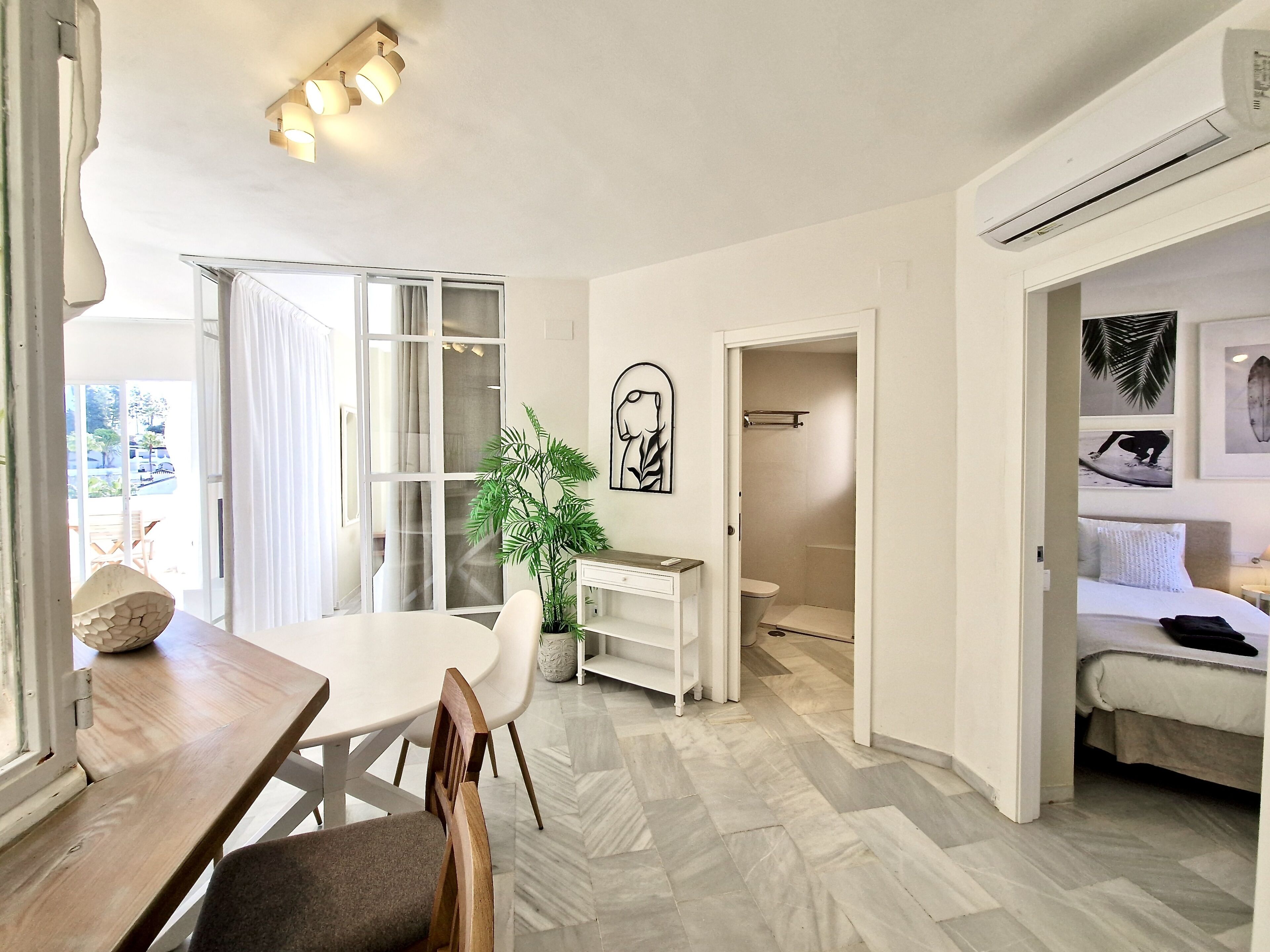 Ein modernes Hotelzimmer mit Essbereich, Dusche und Bett.