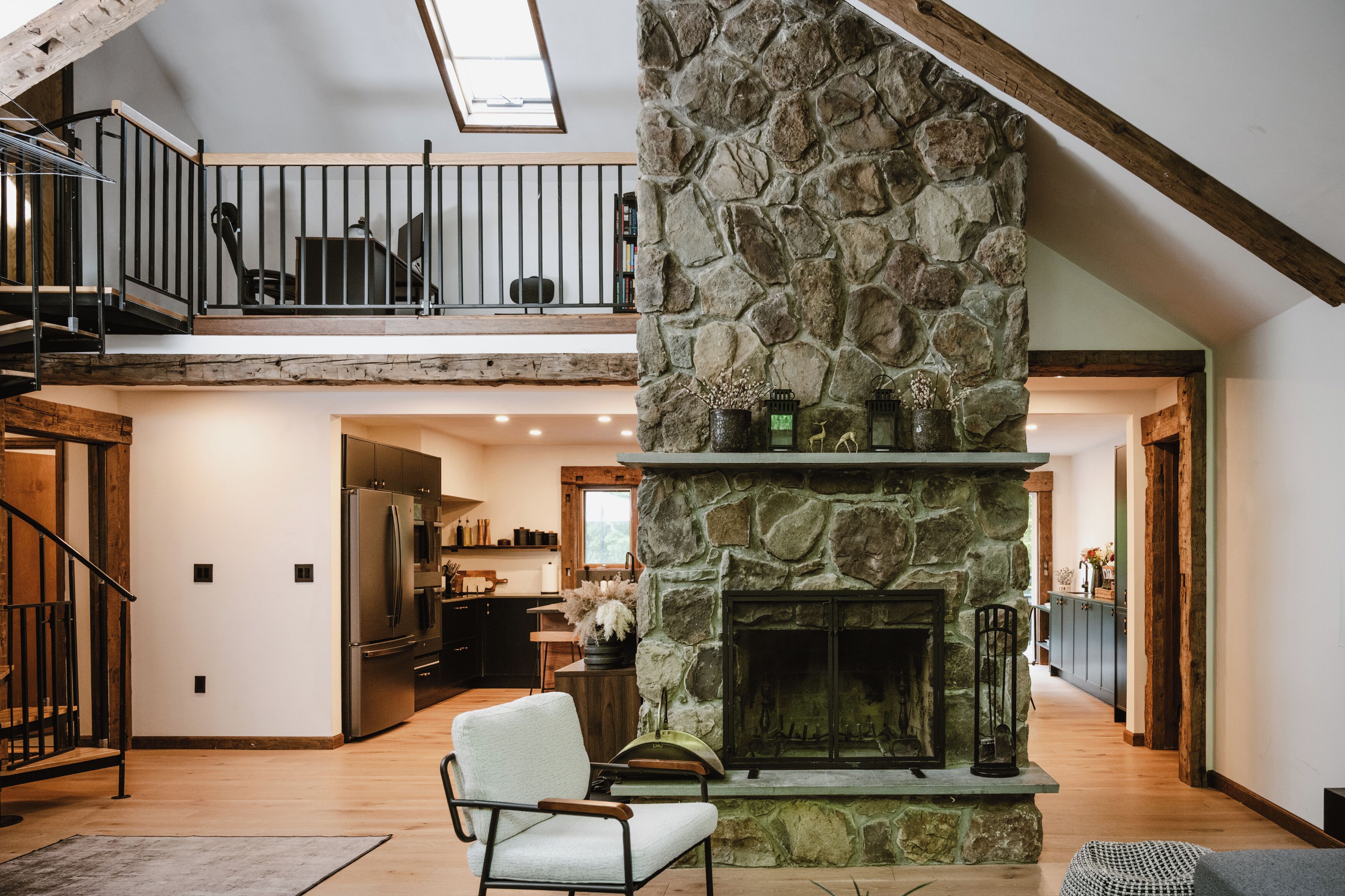 A spacious interior with a stone fireplace, a dining area, and a kitchen.