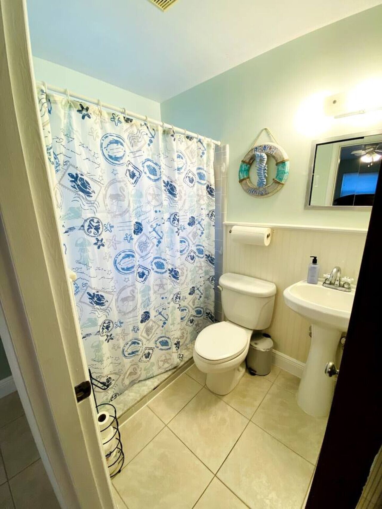 A bathroom with a toilet, sink, and shower curtain.