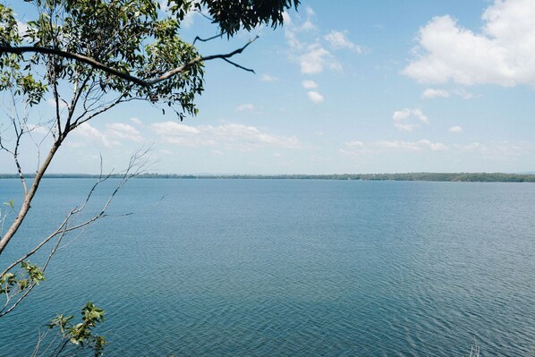 Un lago tranquilo bajo un cielo despejado y tierra a lo lejos.