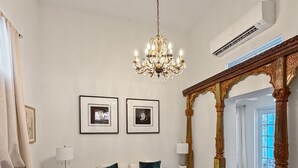 A spacious living room with a chandelier, a sofa set, a coffee table, and a checkered floor. - Elegant Colonial Retreat in Mayagüez - 2BR/2BA (Mayagüez)