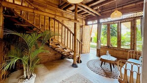 A wooden interior with a staircase, large windows, and a hanging light fixture. - Casa Alonia (Uluwatu)