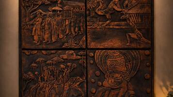 Un detallado panel de madera con escenas talladas que representan diversas actividades culturales e históricas.