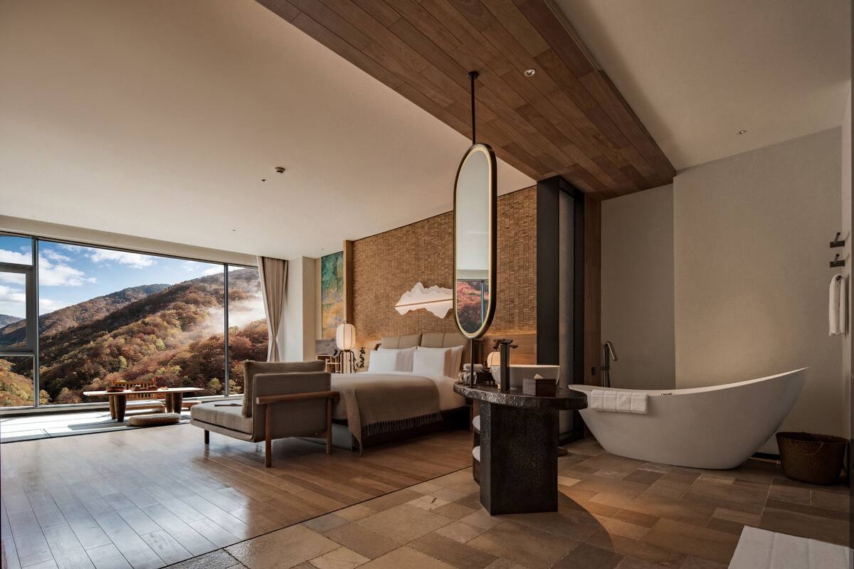 A modern bathroom with a freestanding bathtub, a large mirror, and a wooden ceiling.