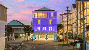 A multi-story building with a balcony, a stop sign, and a bike route sign. - Tropical Castle | 12BR Retreat w/ Pool | Sleeps 50 (North Myrtle Beach)