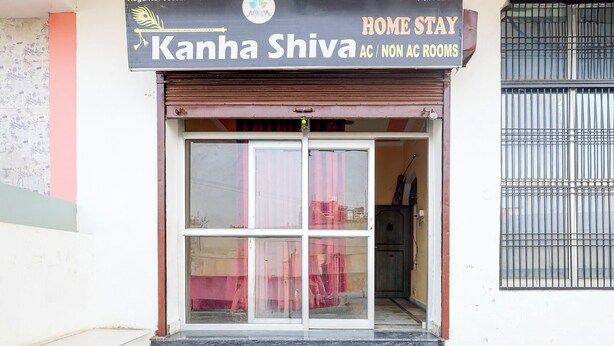 A hotel entrance with a signboard for "Kanha Shiva" offering AC and non-AC rooms. - Via Kanha Shiva (Ayodhya)