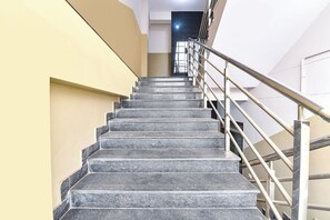 Una escalera con barandillas metálicas que sube a un piso superior.