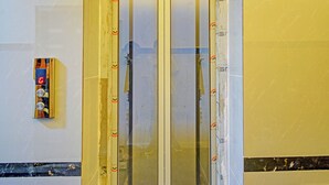 An elevator with a digital display and buttons, surrounded by construction materials and tape.