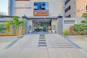 L’entrée de l’hôtel Garapati Grand, avec une enseigne indiquant « Chambres de qualité supérieure – 4 couleurs | Restaurant ».