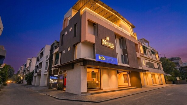 A modern hotel building with a flat roof, large windows, and a sign for 'Nexus' and 'fabHOTELS'. - Fabhotel Nexus (Indore)