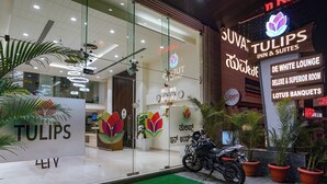 A hotel entrance with a sign for 'Tulips Inn & Suites' and 'De White Lounge'. - Oriva Tulips Inn and Suites - Nr. Majestic (Bengaluru)