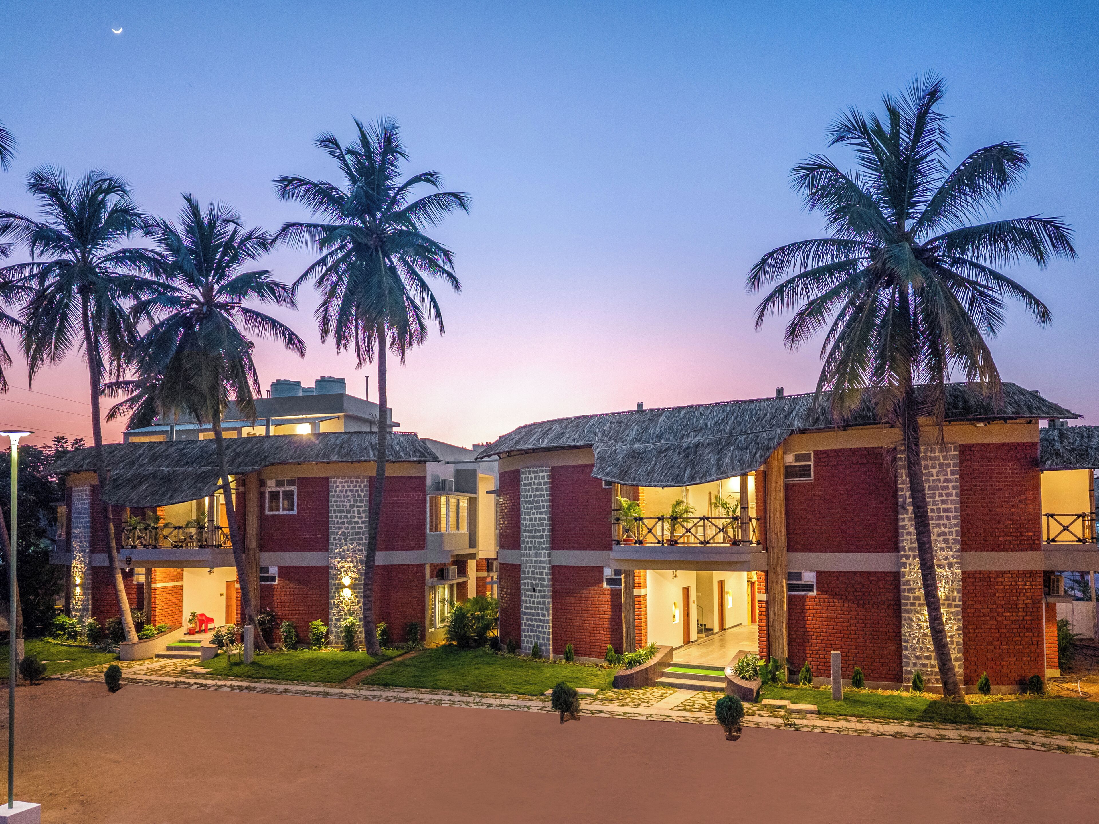 A hotel with multiple rooms, a central lobby, and palm trees.