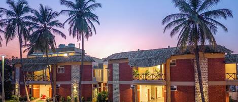 A hotel with multiple rooms, a central lobby, and palm trees.