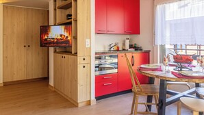 Eine Küche mit Holdekor, einer roten Arbeitsplatte und einem Essbereich mit Tisch und Stühlen.