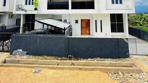 A modern two-story building with a flat roof, large windows, and a covered entrance area. - Recks Luxury Homes (Abuja)
