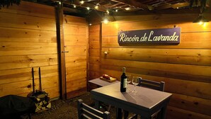A wooden outdoor dining area with a table and chairs, a bottle of wine, and a sign reading "Rincón de Lavanda". - Natural Romance in Glamping Rincón de Lavanda (Texcoco de Mora)