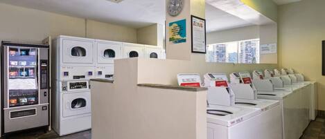 A laundromat with multiple washing machines and a self-service laundry machine.