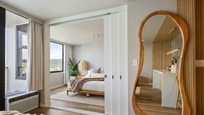 Ein modernes Schlafzimmer mit einem großen Bett, einem begehbaren Kleiderschrank und einem großen Spiegel.