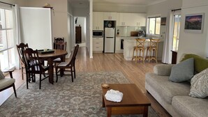 Een ruime woonkamer met een eethoek, keuken en uitzicht op het omliggende landschap.