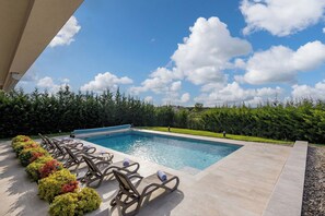 A swimming pool with lounge chairs and a clear sky. - Luxury Pool & Spa Villa Miracle (Brtonigla)