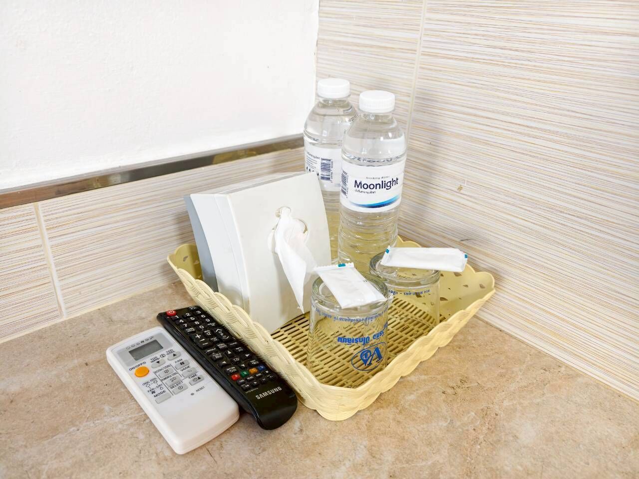 Un ripiano del bagno con una calcolatrice, un telecomando e due bottiglie d'acqua Moonlight.